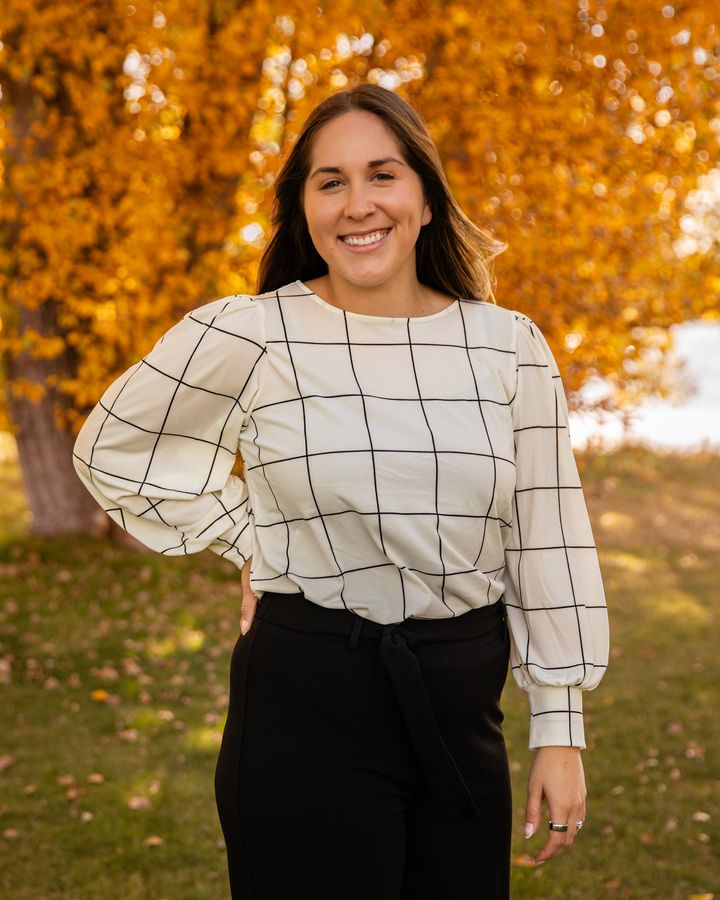 Davaney Semler smiling in front of golden fall leaves